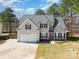 Inviting two-story home with a well-manicured lawn and attached garage at 148 Painted Bunting Dr, Troutman, NC 28166