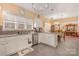 Charming kitchen with white cabinets, modern appliances, stainless steel sink, and stylish gray backsplash at 148 Painted Bunting Dr, Troutman, NC 28166