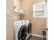 Practical laundry room featuring a modern washer and dryer, storage shelf, and natural light at 148 Painted Bunting Dr, Troutman, NC 28166
