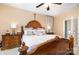 Comfortable main bedroom with a carved wood bed, plush bedding, side tables and soft lighting at 148 Painted Bunting Dr, Troutman, NC 28166