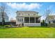 Well-maintained yard boasts a covered patio and fire pit area, perfect for relaxing outdoors at 15307 Country Lake Dr, Pineville, NC 28134