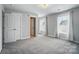Spacious bedroom featuring plush carpet, two windows allowing plenty of natural light and a doorway to an attached bathroom at 15307 Country Lake Dr, Pineville, NC 28134