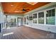 Relaxing covered deck features wood ceilings and flooring, a ceiling fan, and a television mounted on the exterior wall at 15307 Country Lake Dr, Pineville, NC 28134