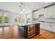 Bright kitchen with an island that includes a wine fridge, sink, and granite countertops at 15307 Country Lake Dr, Pineville, NC 28134