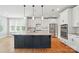 Modern kitchen with white cabinets, granite countertops, stainless steel appliances, and a dark blue island at 15307 Country Lake Dr, Pineville, NC 28134