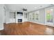 Bright living room featuring a fireplace with built-ins, hardwood floors, and a door leading to a balcony at 15307 Country Lake Dr, Pineville, NC 28134