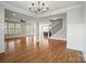 Open-concept living room with hardwood floors leading to a kitchen, stairs, and a dining area at 15307 Country Lake Dr, Pineville, NC 28134