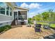 Backyard patio has a built-in stone firepit with chairs, a grill, and stairs leading to a screened in back porch at 15307 Country Lake Dr, Pineville, NC 28134