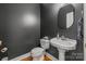 Chic powder room featuring a pedestal sink, elegant mirror, and hardwood floors at 1919 46Th Avenue Ne Dr # 46, Hickory, NC 28601