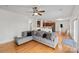 Open-concept living space with hardwood floors, a large gray sofa, and seamless transition to the kitchen at 1919 46Th Avenue Ne Dr # 46, Hickory, NC 28601