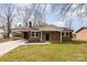 Charming brick home featuring a covered carport, manicured lawn, and inviting front entrance at 209 Palmer St, Shelby, NC 28150