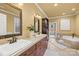 Bright bathroom features double sinks, dark wood cabinetry, and a relaxing soaking tub at 228 Wildwood Cove Dr, Mooresville, NC 28117