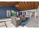 Relax in this covered patio featuring a large screen TV, comfortable seating, and stylish outdoor decor at 228 Wildwood Cove Dr, Mooresville, NC 28117