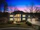 Stunning two-story home with a stone-accented facade and a three-car garage, beautifully lit at dusk at 228 Wildwood Cove Dr, Mooresville, NC 28117