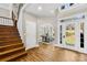 Bright foyer featuring wood floors, a staircase, and a view into the dining room at 228 Wildwood Cove Dr, Mooresville, NC 28117