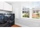Convenient laundry room with tile floors, storage cabinets, and modern washer and dryer at 228 Wildwood Cove Dr, Mooresville, NC 28117