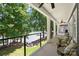 Covered porch overlooking the lake and lush greenery with stylish seating and ceiling fans at 228 Wildwood Cove Dr, Mooresville, NC 28117