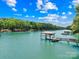 Stunning waterfront view featuring a private covered dock with serene water and lush trees at 228 Wildwood Cove Dr, Mooresville, NC 28117