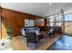 Stylish living room with wood paneled walls, modern furniture, and access to a sunroom through glass doors at 2300 Cloister Dr, Charlotte, NC 28211