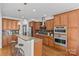 Kitchen featuring wood cabinets, granite counters, stainless steel appliances, and seating at the island at 2464 Chatham Dr, Indian Land, SC 29707