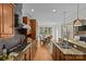 Kitchen view showing wooden cabinets, granite countertops, a cooktop, and views to the dining area at 2464 Chatham Dr, Indian Land, SC 29707