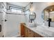 Bright bathroom featuring double sink vanity, granite countertop, wooden cabinets and glass enclosed shower with contrasting tile at 416 E 18Th St, Charlotte, NC 28206