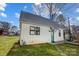 Charming cottage-style home featuring white siding, a striking metal roof, and a welcoming blue front door at 416 E 18Th St, Charlotte, NC 28206