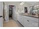Well-lit bathroom with granite counters, dual sinks, and a walk-in closet at 4288 Legacy Dr, Denver, NC 28037