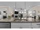 Kitchen island with granite countertop, stainless sink and faucet, and views to the living room at 4288 Legacy Dr, Denver, NC 28037