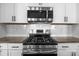 A close up of a modern gas range and stainless steel microwave in a modern kitchen at 4288 Legacy Dr, Denver, NC 28037