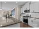 Modern kitchen boasts stainless steel appliances, granite countertops, and sleek white cabinetry at 4288 Legacy Dr, Denver, NC 28037
