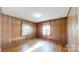 Bedroom with wood paneling, hardwood floors, and windows with natural light at 4774 E Nc 150 Hwy, Lincolnton, NC 28092