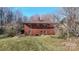 Brick home with a brown roof surrounded by a mix of trees and some grass and hillside at 4774 E Nc 150 Hwy, Lincolnton, NC 28092