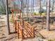Landscaped backyard featuring a wooden bridge, arbor, and serene wooded backdrop at 549 Briarwood Ln, Lancaster, SC 29720