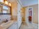 Well-lit bathroom features a single sink vanity with tiled backsplash and a door leading to another room at 549 Briarwood Ln, Lancaster, SC 29720