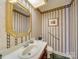 Elegant bathroom with decorative mirror, vanity, and stylish striped wallpaper at 549 Briarwood Ln, Lancaster, SC 29720