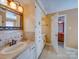 Bathroom featuring single vanity with decorative mirror, and a doorway to a bedroom at 549 Briarwood Ln, Lancaster, SC 29720