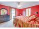 Bright bedroom features red walls, plush bedding, and a ceiling fan for added comfort at 549 Briarwood Ln, Lancaster, SC 29720