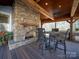 Covered patio with stone fireplace, wooden ceiling and furniture at 549 Briarwood Ln, Lancaster, SC 29720