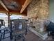 Covered outdoor patio featuring a stone fireplace, ceiling fan, and ample seating at 549 Briarwood Ln, Lancaster, SC 29720