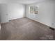 Spacious carpeted bedroom with ample natural light and neutral wall color at 6108 Heath Ridge Ct, Charlotte, NC 28210