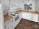 Bright kitchen featuring white appliances and cabinets with wood countertop and view out the window at 6108 Heath Ridge Ct, Charlotte, NC 28210