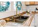 Close-up of a kitchen sink with a gold faucet, wooden countertop, and a decorative plant at 612 Miller St, Kannapolis, NC 28081