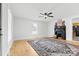 Bright living room with hardwood floors, a ceiling fan, and a decorative fireplace with an ornate rug at 612 Miller St, Kannapolis, NC 28081