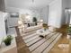 Bright, staged living room featuring a fireplace, large windows, modern furnishings, and a striped rug on wood floors at 6440 Tivoli Ct, Charlotte, NC 28211