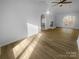 Open living room featuring new floors, a modern ceiling fan, a fireplace and plenty of natural light at 6440 Tivoli Ct, Charlotte, NC 28211