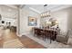 Open dining room with a modern chandelier, art, and plenty of seating for entertaining at 6727 Baker Creek Ave, Indian Land, SC 29707