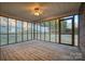 Enclosed porch with wood flooring, windows and a ceiling fan at 924 41St Avenue Ne Dr, Hickory, NC 28601