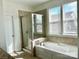 A bathroom showcasing a tiled shower and tub alongside natural window lighting at 1019 Dunhill Ln, Waxhaw, NC 28173