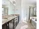 A well-lit bathroom featuring double sinks, tiled floors, and a glass shower at 1019 Dunhill Ln, Waxhaw, NC 28173